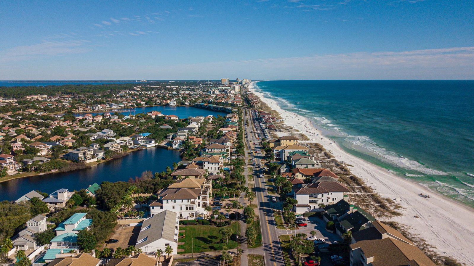 aerial view of houses near a beach under blue sky