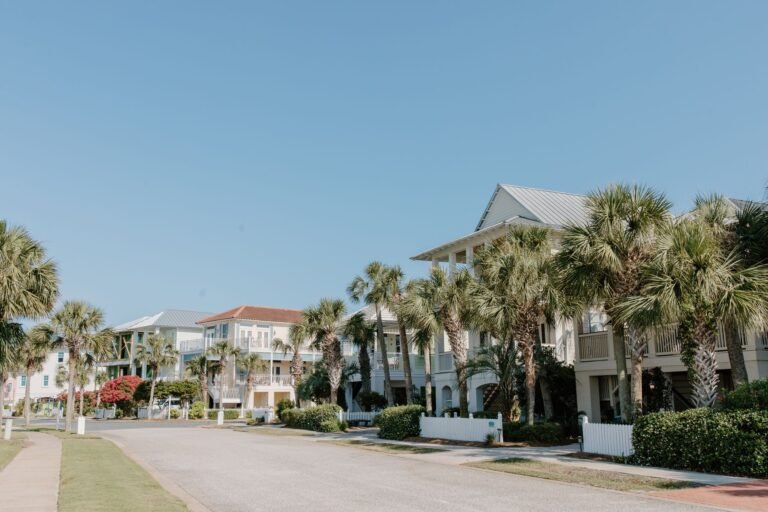 a row of houses near green trees under blue sky