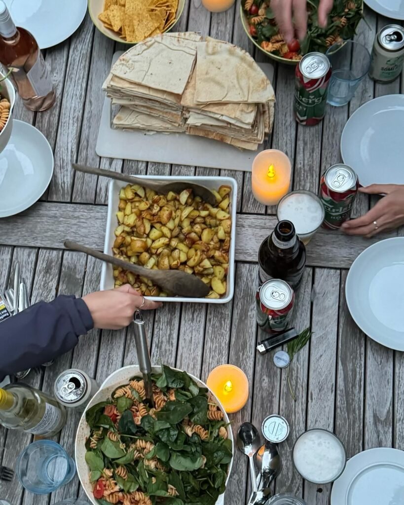 Tablescape with food and beverages being enjoyed by friends similar to the way meals are had on a vacation at the beach. This demonstrated another way you can bring home the feeling of being on vacation